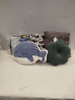 un lit sur lequel se trouvent deux oreillers et une baleine en peluche