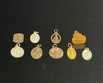 several gold and silver charms on a black surface