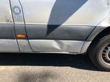 a silver van that has been vandalized with a sticker on it