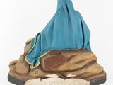 figurine of a woman in a blue robe sitting on a rock