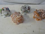 cinq petites figurines de formes et de tailles différentes posées sur une surface blanche