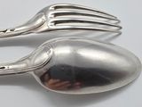 two silver spoons and a fork on a table