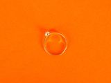 an orange background with a silver ring on top of it
