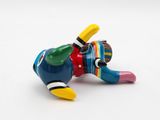 a colorful figurine of a dog laying down on the ground