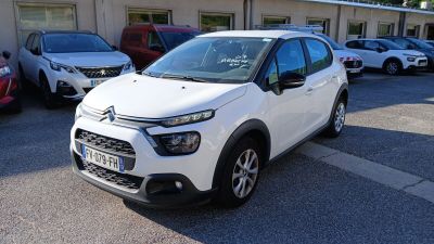 la voiture blanche est garée devant un bâtiment dans un parking