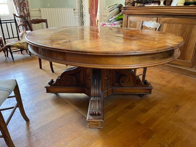 une grande table en bois au milieu d'une pièce