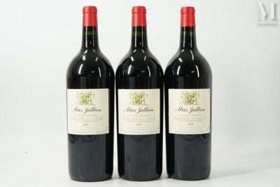 three bottles of red wine sitting on top of a white table