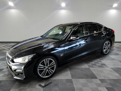 une Infiniti noire garée sur un sol en carrelage à damier