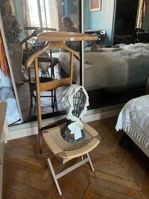 une petite table sur laquelle est posé un ventilateur, à côté d'un lit