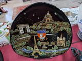 une assiette sur laquelle est représentée une ville, posée sur une table