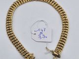 a close up of a gold bracelet with a tag on it