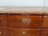 a wooden dresser with marble top in a room