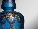 a blue vase with a gold design on it