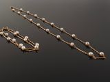 pearl and gold necklace and earring set on a black surface