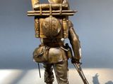 bronze statue of a soldier with a rifle and a bird on his back