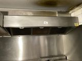a stainless steel kitchen with a stove and a range hood