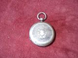 a small silver pocket watch on a red cloth