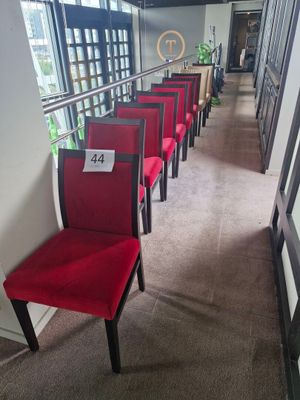 several red chairs are lined up in a row in a hallway