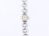 a close up of a watch on a chain on a white background