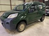 une photo d'une petite camionnette verte garée dans un garage