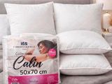 deux oreillers sur un lit, avec un oreiller posé dessus