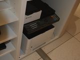 a printer sitting on top of a shelf in a room