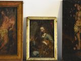 trois tableaux encadrés représentant Jésus et d'autres figures religieuses, posés sur une étagère