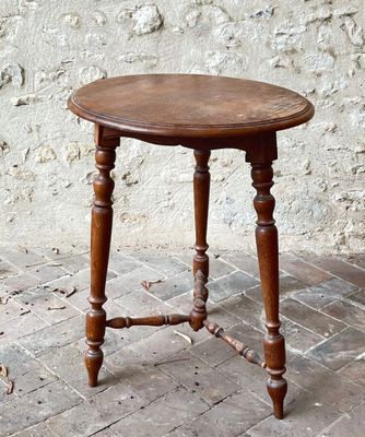 a small wooden table with a wooden top on a brick floor