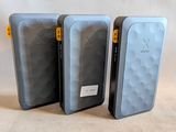 trois téléphones portables sont alignés les uns à côté des autres sur une surface blanche