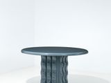 une image représentant une table au plateau noir posée sur une surface blanche