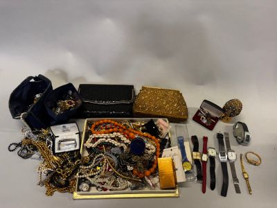 une boîte contenant un assortiment de bijoux posée sur une surface blanche