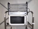 a microwave sitting on top of a metal shelf