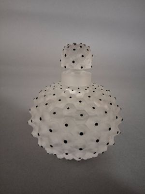 un vase blanc orné de pois noirs