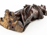 wooden statue of a person laying down on a white surface