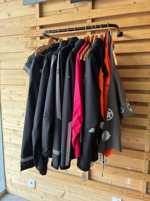 several jackets hanging on a rack in a room