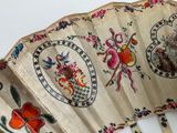 a close up of a hand painted fan on a table