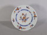 une assiette bleue et blanche ornée de fleurs orange