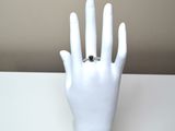 a white mannequin hand with a ring on it