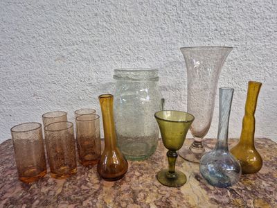 de nombreux vases et verres en verre de différentes couleurs posés sur une table
