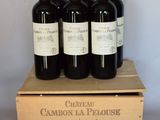 six bouteilles de vin rouge dans un coffret en bois sur une table