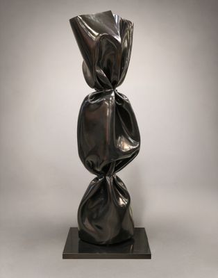 une sculpture représentant une sculpture noire posée sur un socle noir
