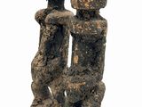statue of two people sitting on top of a wooden block