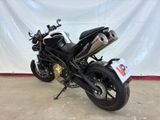 motorcycle parked in front of a white backdrop in a garage