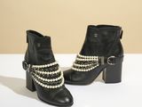 une paire de bottines en cuir noir ornées de perles et de boucles