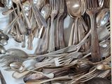 many spoons and forks in a box on the table