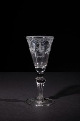 a close up of a wine glass on a table with a black background