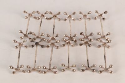 silver plated beads are arranged in a row on a white surface