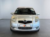 a silver toyota yaris parked in a white room