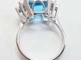 an image of a ring with a blue topaz stone surrounded by diamonds