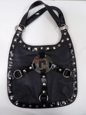 porte-monnaie en cuir noir orné de rivets et de boucles sur un fond blanc